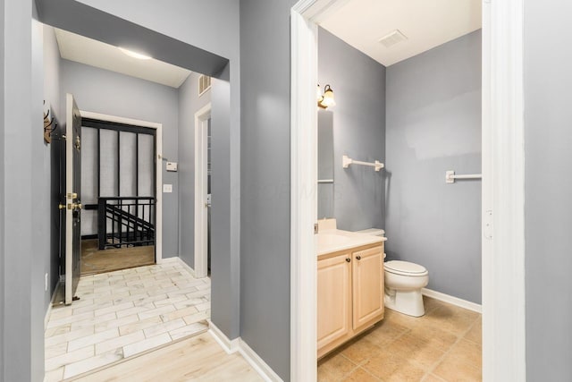 bathroom with visible vents, baseboards, toilet, and vanity