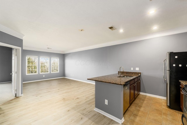 kitchen with visible vents, a sink, stainless steel appliances, dark stone counters, and a peninsula