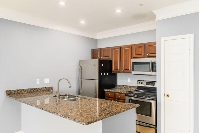 kitchen with ornamental molding, dark stone countertops, a peninsula, stainless steel appliances, and a sink