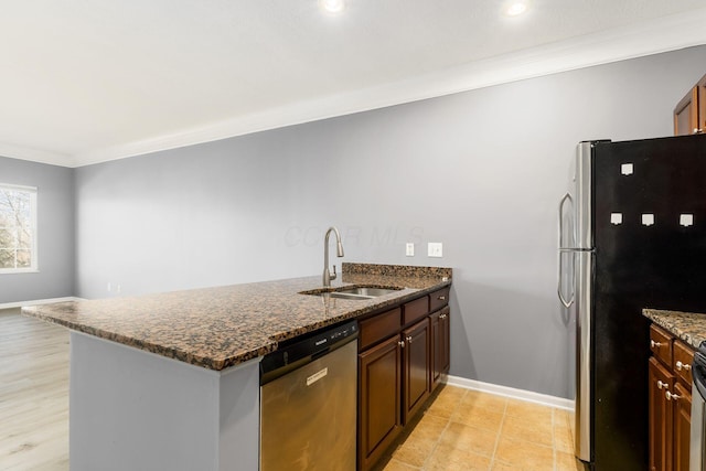 kitchen featuring a peninsula, dark stone counters, a sink, stainless steel appliances, and crown molding