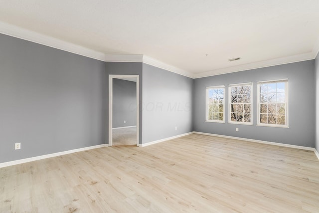 unfurnished room with visible vents, baseboards, light wood-style flooring, and ornamental molding