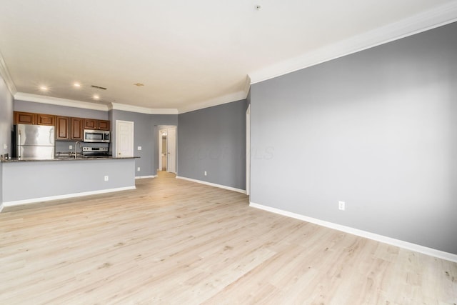 unfurnished living room featuring ornamental molding, a sink, recessed lighting, light wood finished floors, and baseboards