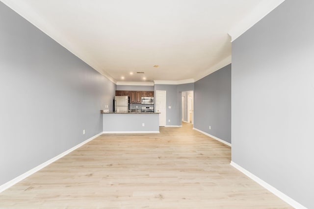 unfurnished living room featuring baseboards, ornamental molding, and light wood finished floors