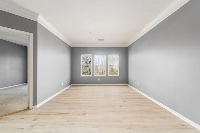 unfurnished room featuring crown molding, light wood-style flooring, baseboards, and visible vents