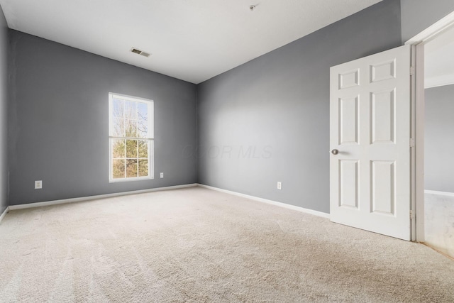 carpeted empty room featuring visible vents and baseboards