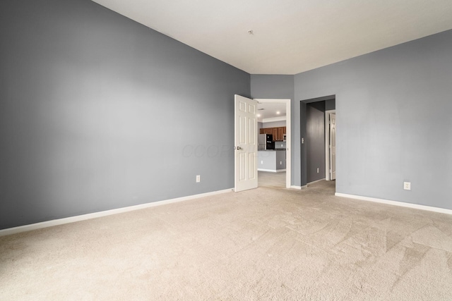 empty room with baseboards and light carpet