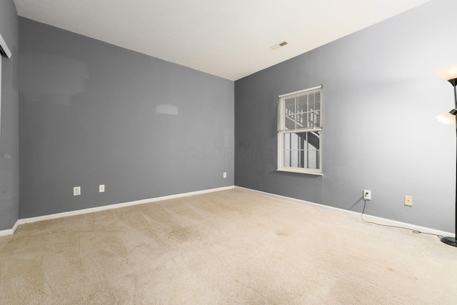 empty room with carpet flooring, baseboards, and visible vents