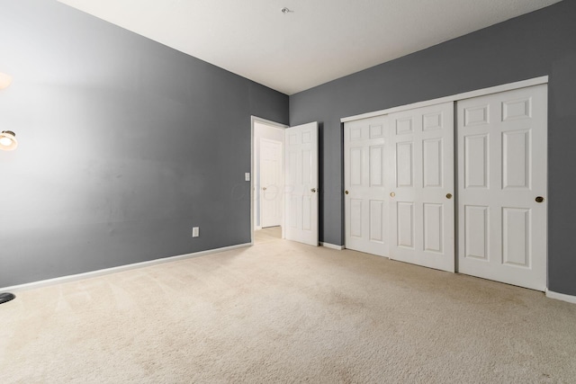 unfurnished bedroom with a closet, baseboards, and carpet