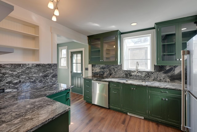 kitchen featuring a sink, stainless steel appliances, green cabinets, and dark wood finished floors