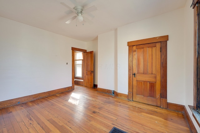 spare room featuring visible vents, baseboards, light wood finished floors, and ceiling fan