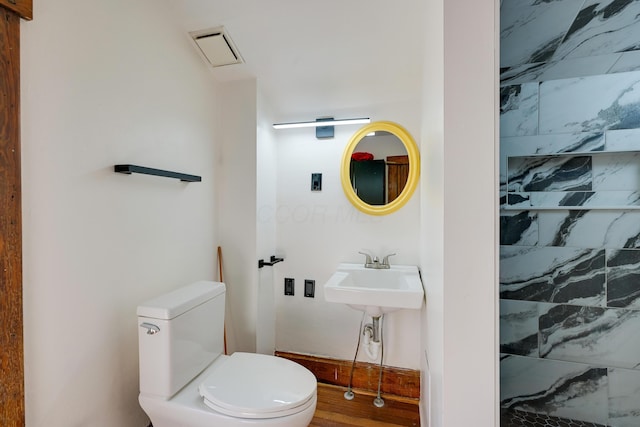 bathroom featuring a sink, visible vents, and toilet