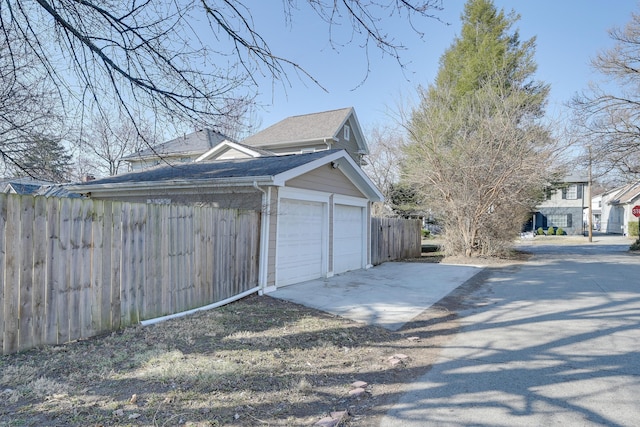 garage with fence and driveway