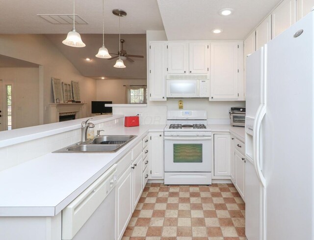 kitchen with visible vents, vaulted ceiling, a sink, a peninsula, and white appliances