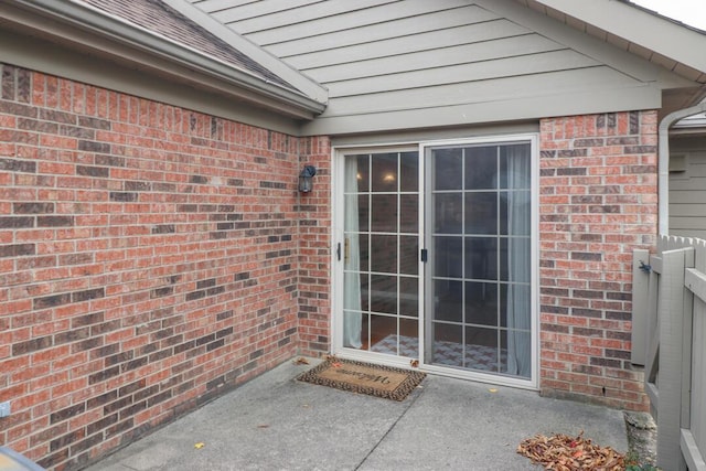 doorway to property with a patio and brick siding