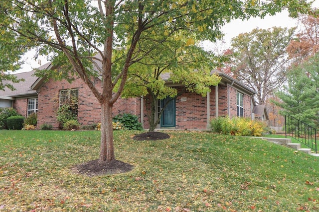 view of front of house with brick siding and a front yard