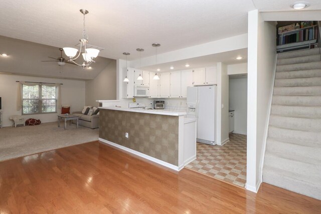 kitchen with white cabinets, a peninsula, open floor plan, light wood-style floors, and white appliances