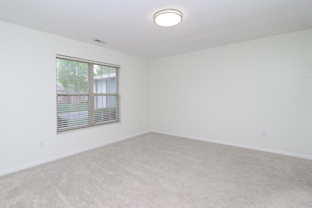 spare room with baseboards, carpet flooring, and visible vents