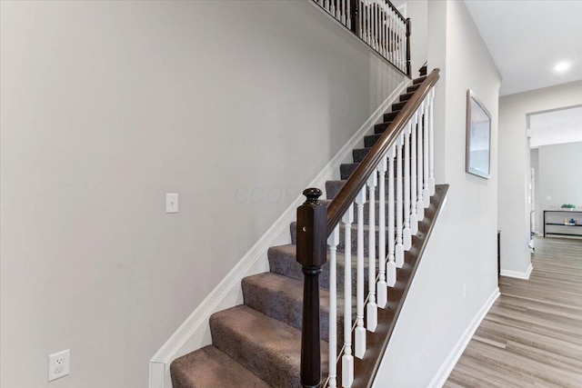 stairway featuring recessed lighting, baseboards, and wood finished floors