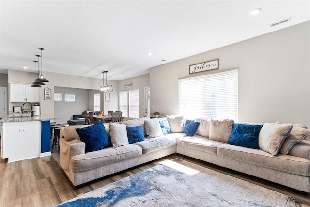 living room with recessed lighting, wood finished floors, and visible vents