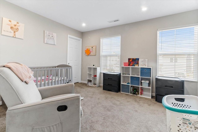 carpeted bedroom with recessed lighting, a nursery area, baseboards, and visible vents