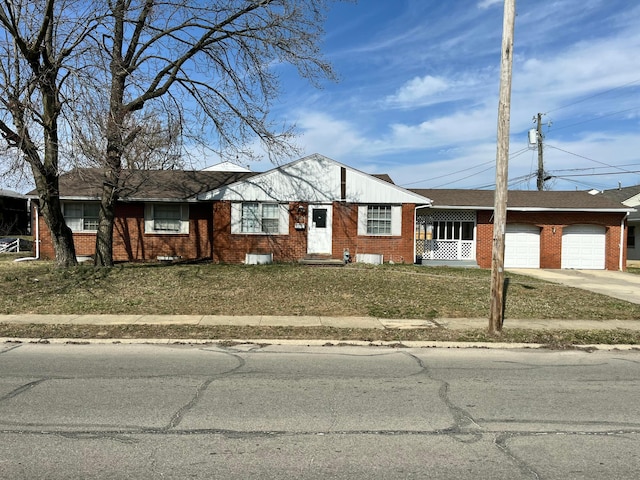 single story home with a front yard, an attached garage, brick siding, and driveway