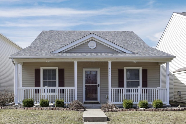 bungalow featuring a porch and roof with shingles