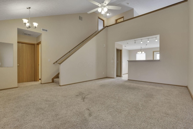 unfurnished living room with visible vents, carpet floors, stairs, and ceiling fan with notable chandelier