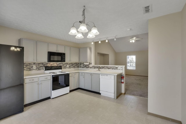 kitchen with visible vents, black appliances, a sink, a peninsula, and light countertops