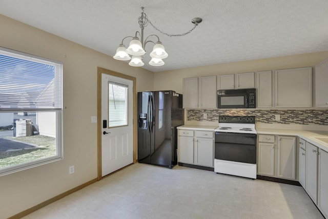 kitchen with black appliances, a notable chandelier, light floors, and tasteful backsplash