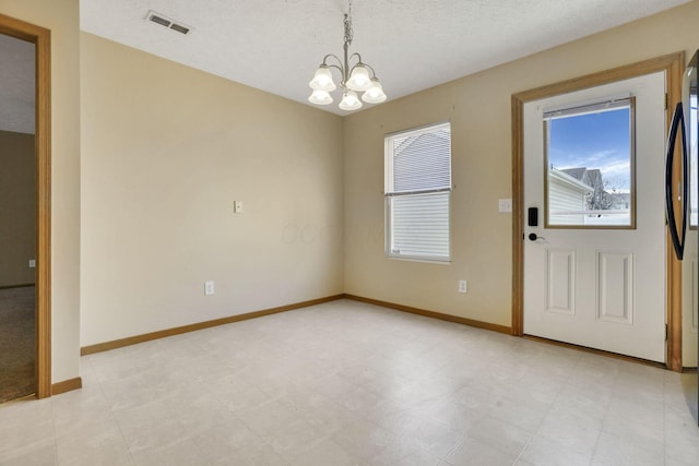 interior space with a wealth of natural light, baseboards, light floors, and an inviting chandelier