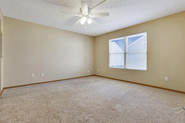 carpeted spare room with a textured ceiling, baseboards, and ceiling fan