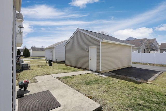 view of outdoor structure with an outbuilding, cooling unit, and fence