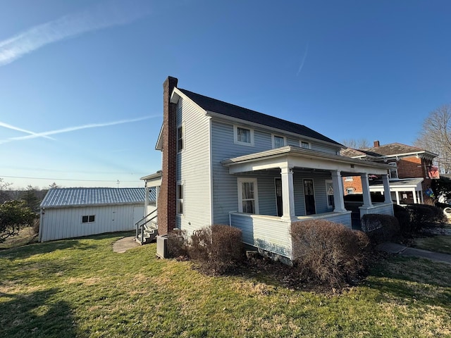 back of house featuring entry steps, central AC unit, covered porch, a chimney, and a yard