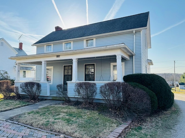 view of front of home featuring a porch and a chimney