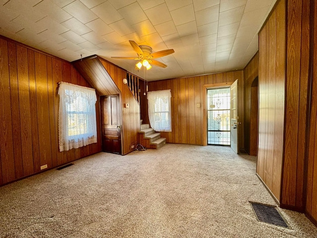 interior space featuring stairway, carpet, visible vents, and ceiling fan