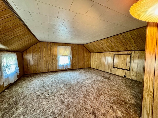 bonus room with lofted ceiling, carpet, and wooden walls