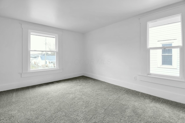 empty room featuring baseboards and carpet