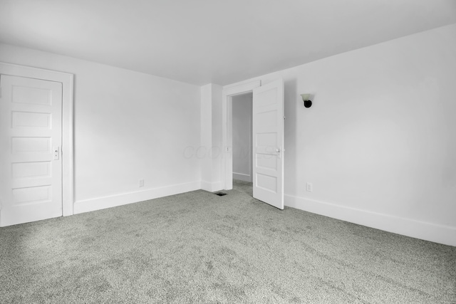 carpeted spare room featuring baseboards