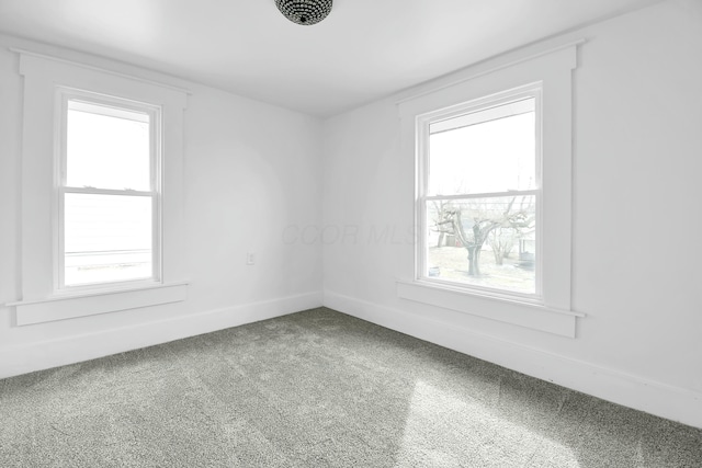 unfurnished room featuring a wealth of natural light, baseboards, and carpet flooring