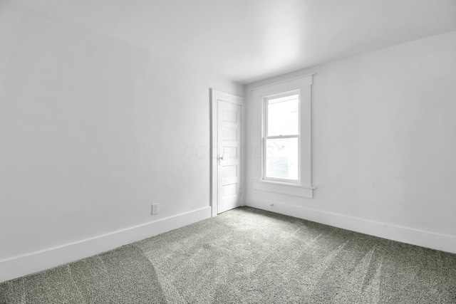 carpeted spare room with baseboards