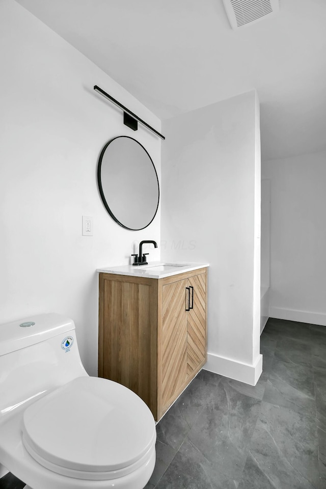 bathroom featuring visible vents, toilet, vanity, and baseboards