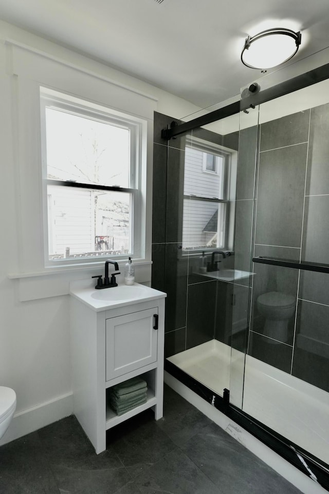 bathroom with vanity, baseboards, a shower stall, tile patterned floors, and toilet