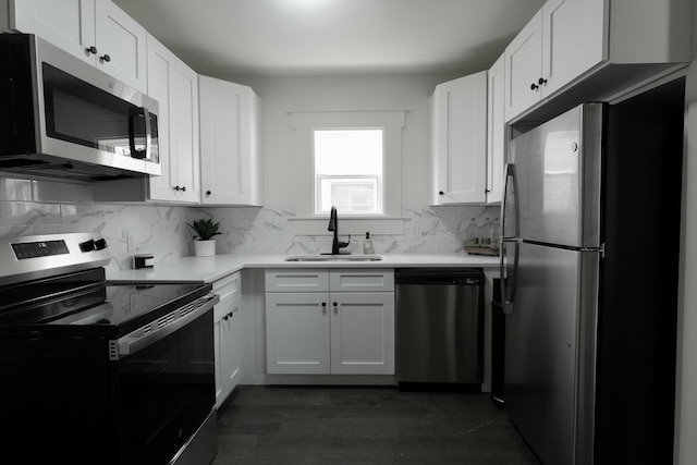 kitchen featuring backsplash, light countertops, appliances with stainless steel finishes, white cabinetry, and a sink