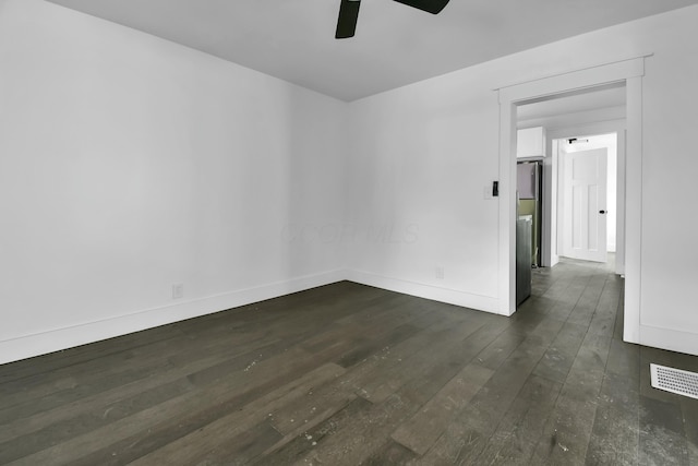 unfurnished room with dark wood-type flooring, visible vents, baseboards, and ceiling fan