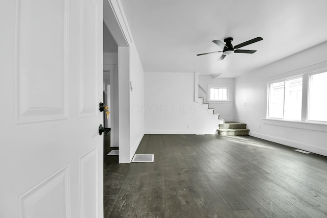 interior space featuring stairway, baseboards, visible vents, ceiling fan, and wood-type flooring