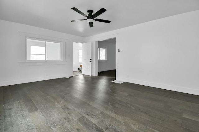 spare room featuring baseboards, dark wood-type flooring, and ceiling fan