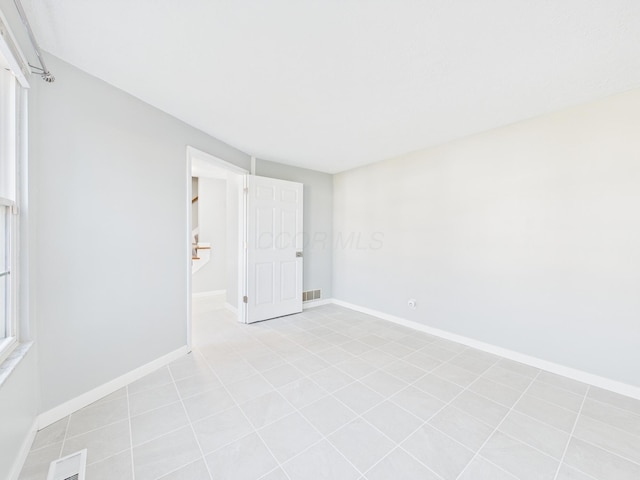 unfurnished room with visible vents and baseboards