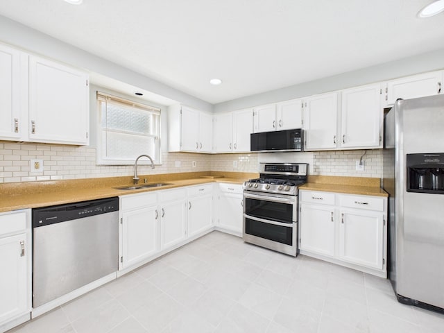 kitchen with white cabinets, appliances with stainless steel finishes, and a sink