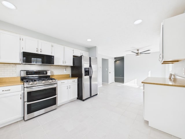 kitchen featuring decorative backsplash, appliances with stainless steel finishes, white cabinetry, and ceiling fan