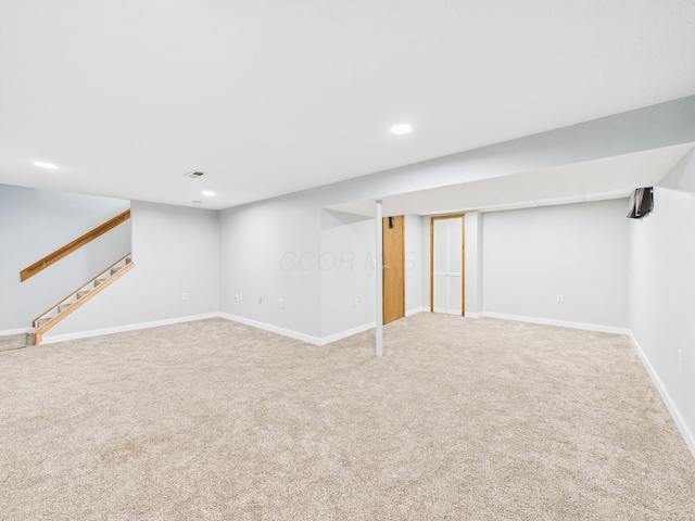 finished below grade area featuring recessed lighting, stairway, visible vents, and carpet flooring